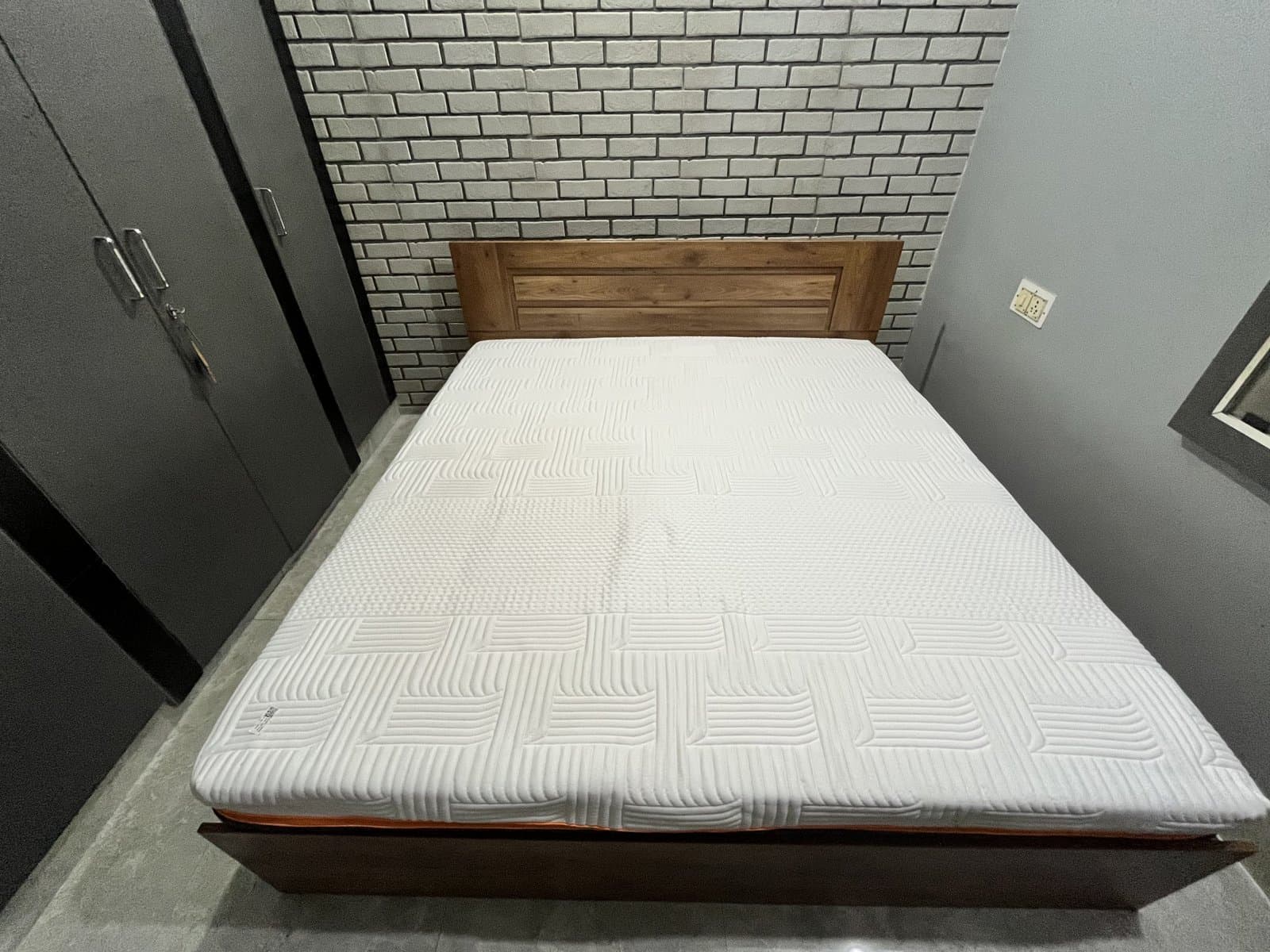 The fully expanded Emma Performance mattress on its frame, seen from the foot of the bed.