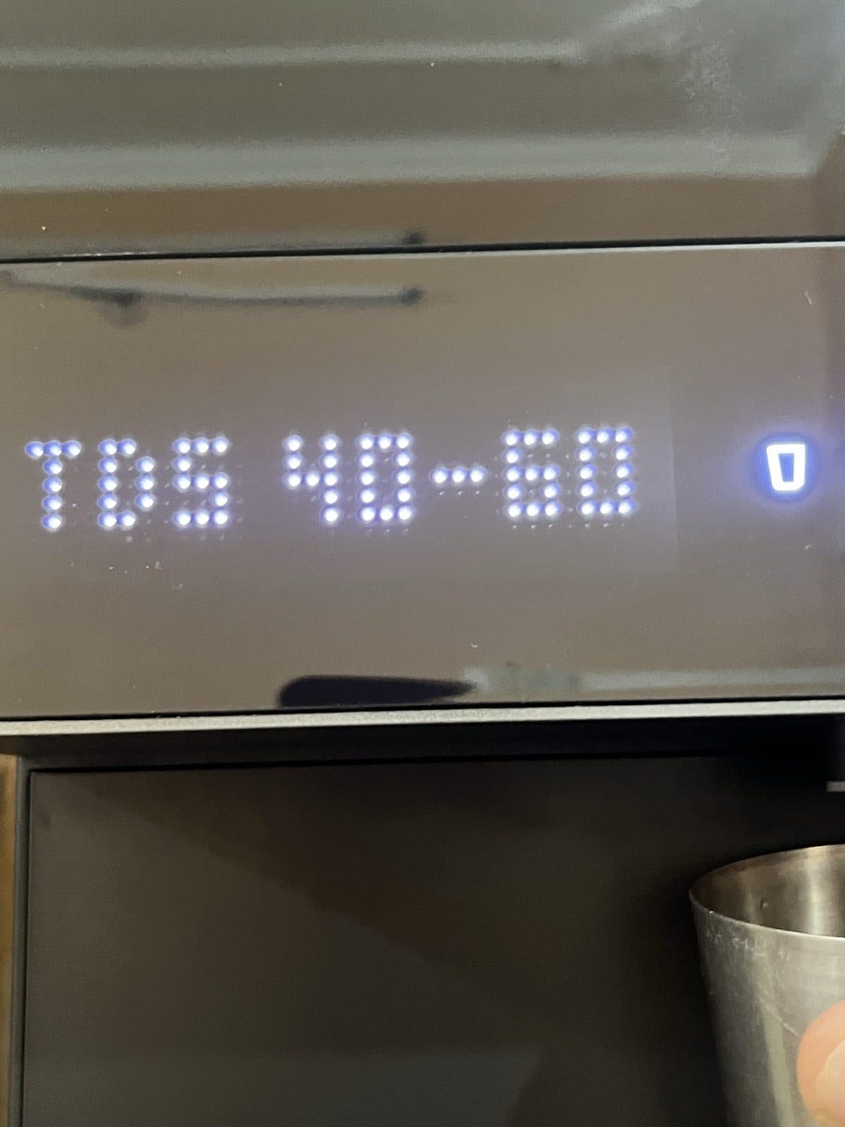 Close-up of the dot-matrix display reading TDS 40-60, next to the lit glass-preset icon.