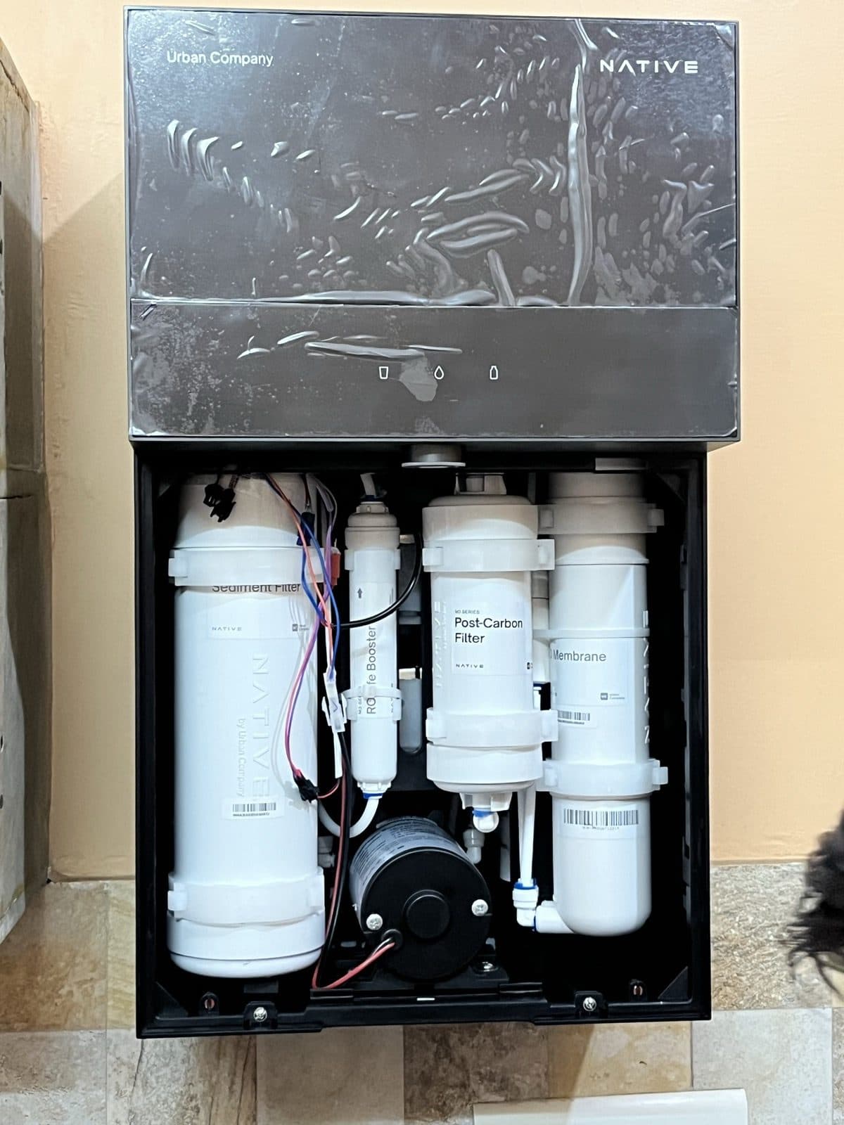The M3 Pro opened up during installation, glass still in its protective film, showing the labelled sediment filter, RO LifeBooster, post-carbon filter and RO membrane, with the pump below.